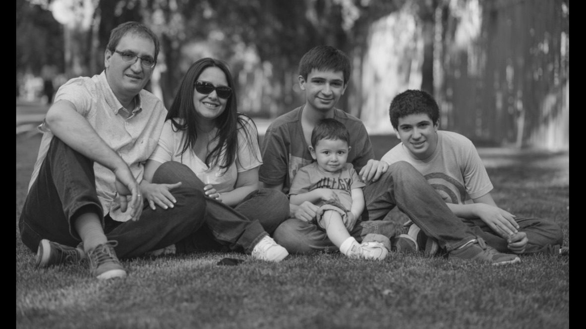 Retrato familiar en blanco y negro, los cinco sentados en el pasto de un parque